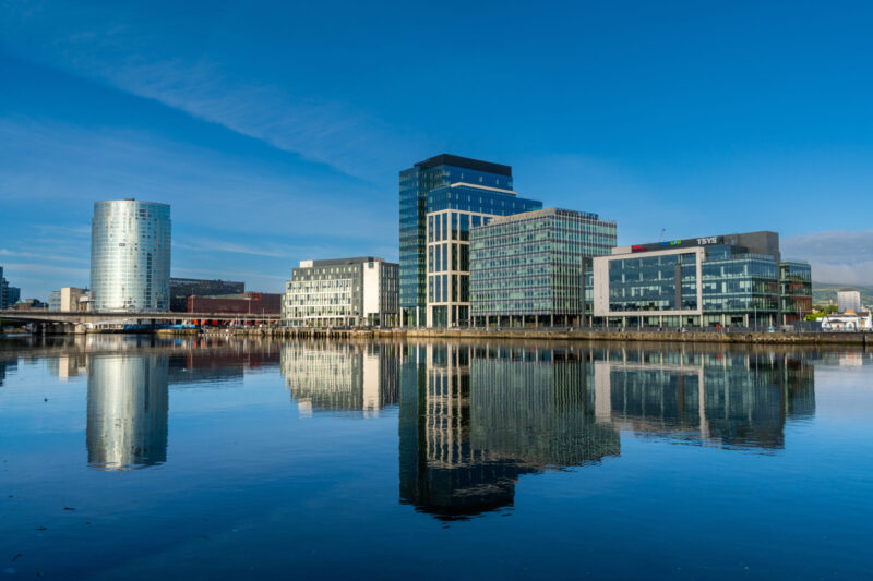 skyline of downtown Belfast with skyscrapers and reflections in the calm River Lagan at dawn